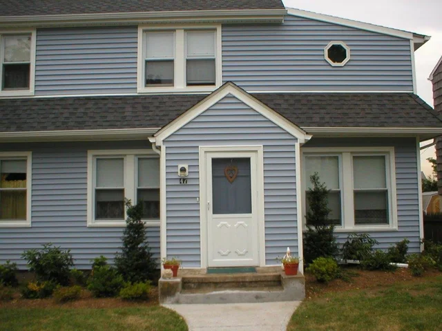 Blue-sided cape with white trim and a new roof