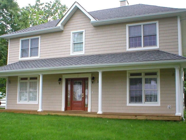 Beige-sided farmhouse with a full-width front porch