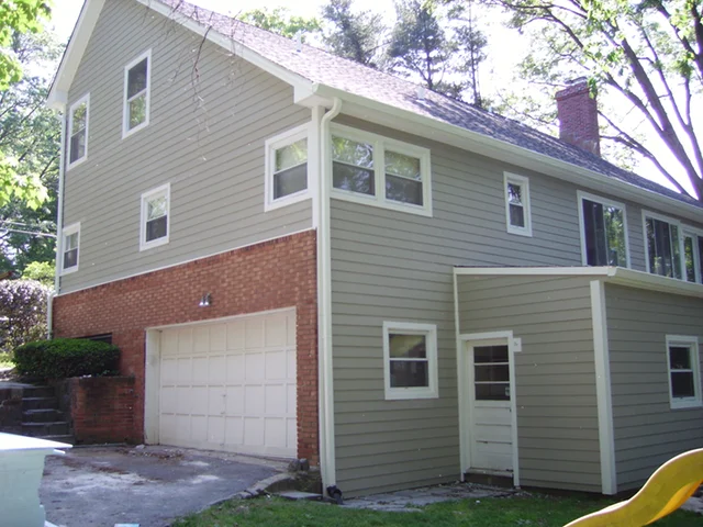 Gray-sided home with a two-story addition over the garage