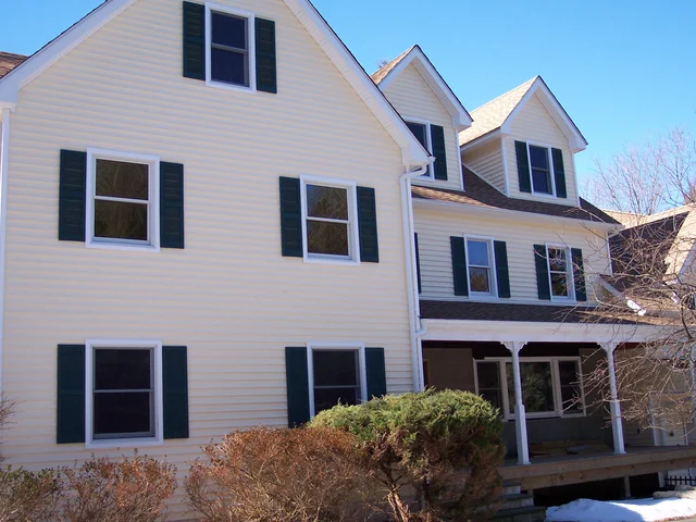 Colonial with white siding, black shutters and new double-hung windows