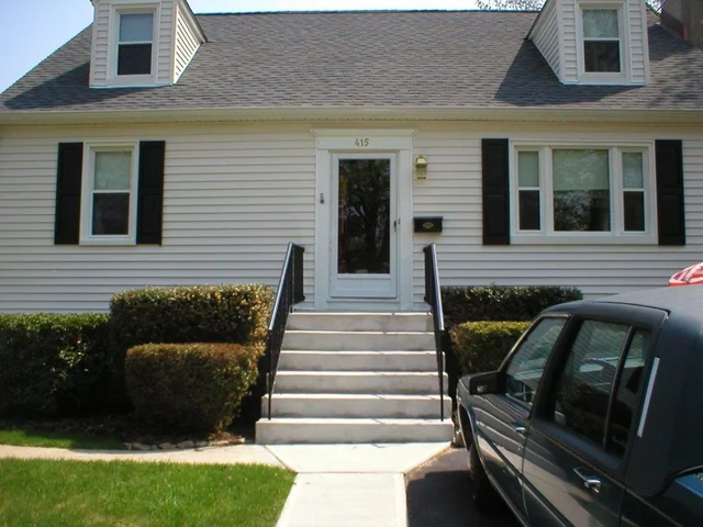 White-sided home with twin dormers and black shutters